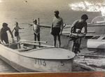 Фото, мужчины снимают мотор с лодки