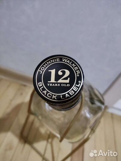 Пустая бутылка виски в подставке качели