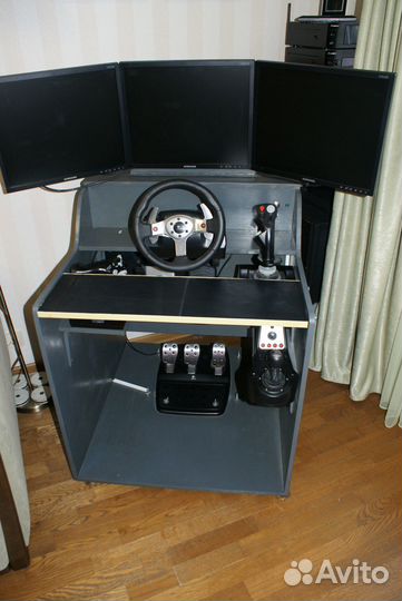Компьютерный стол с мониторами и джойстиками